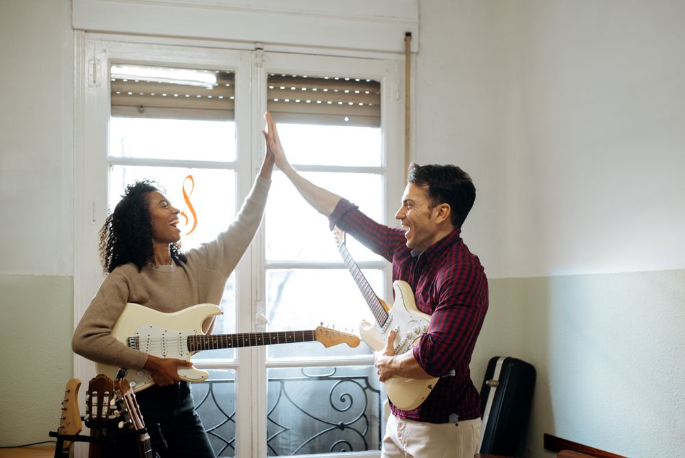 Man and woman playing guitar in studio
