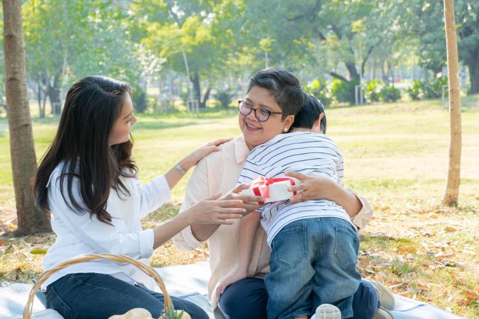 Asian woman and her son giving grandmother a present