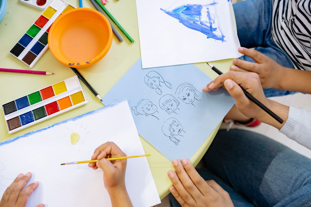 Top view of group of people drawing faces