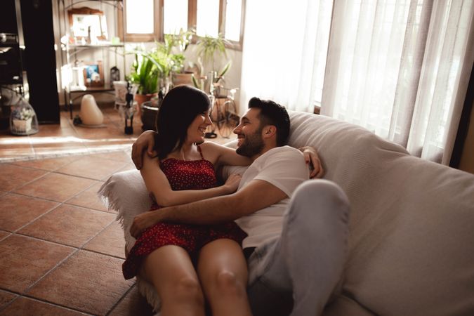 Cheerful couple hugging on sofa