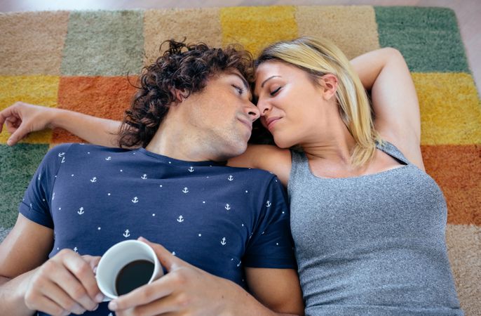 Couple resting lying on the carpet