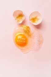 Fresh broken chicken egg covered with glitter with eggshell