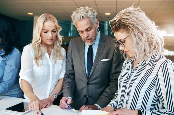 Group of blonde people in business attire discussing plans at work