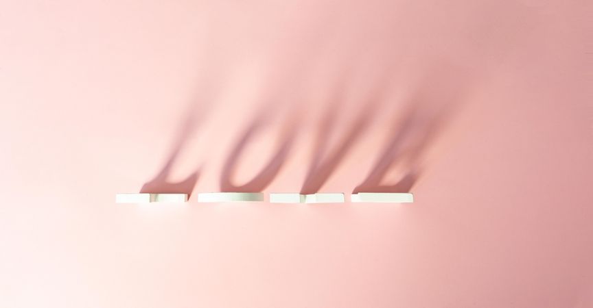 “Love” written in shadow on pink background