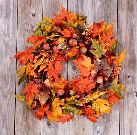 Wreath made of autumn leaves and acorns on rustic wood