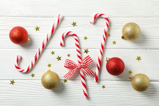 Candy canes and christmas accessories on wooden background, space for text
