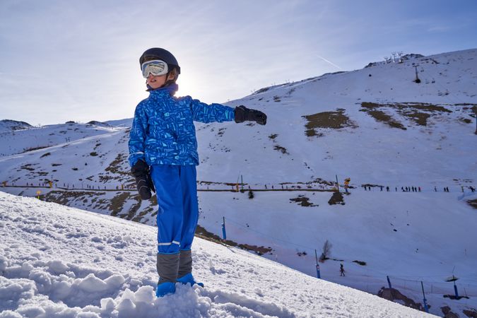 Boy pointing away on ski resort