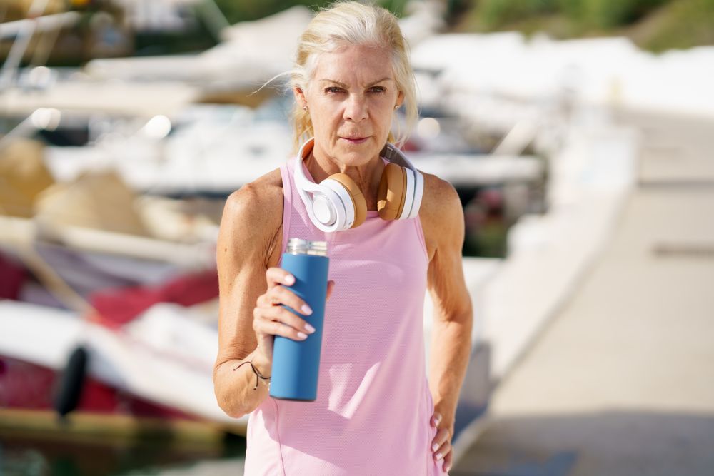 Mature female with grey hair drinking between exercise