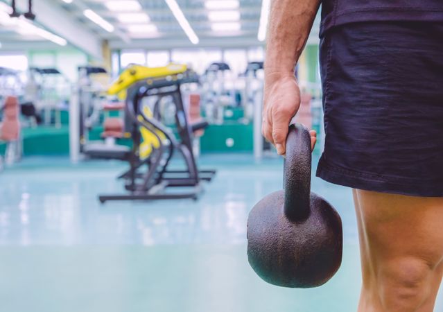 Close up of man holding kettle bell in gym