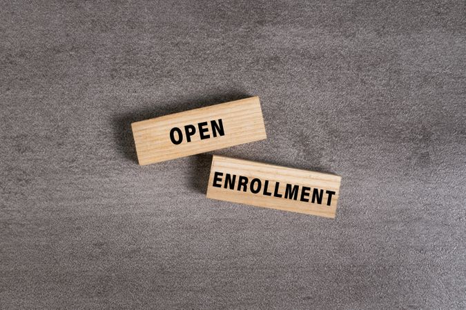 open enrollment words on wooden blocks isolated on cement background