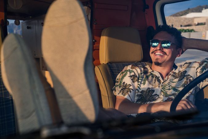 Happy adult man sitting in van