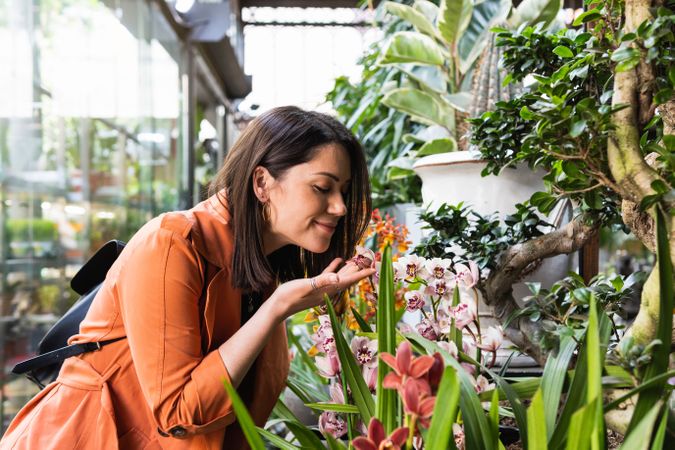 Cheerful woman choosing flowers in garden center