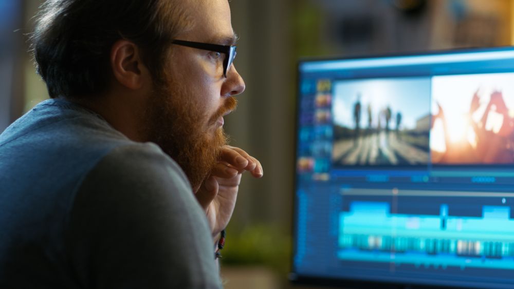Male Video Editor Works with Footage and Sound on His Personal Computer.