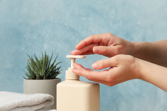 Female hands squeeze liquid soap. Personal hygiene concept