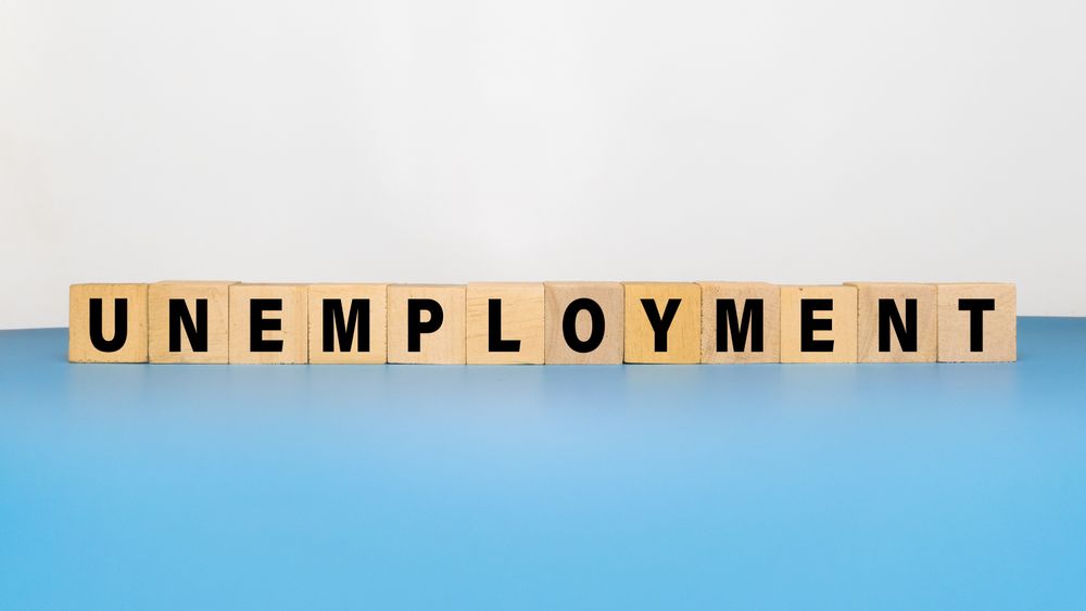 unemployment word text on wooden blocks isolated on blue background