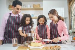 Happy Asian family baking together in the kitchen