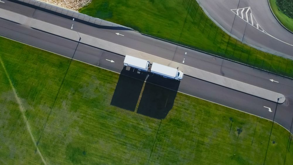 Aerial Shot of Truck with Attached Semi Trailer Leaving Industrial Warehouse