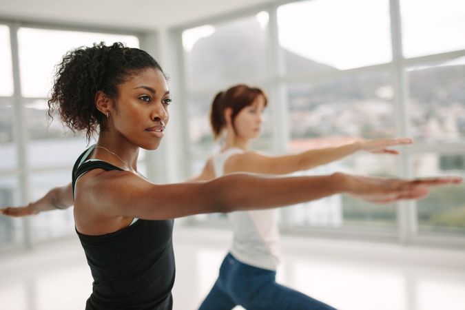 Women performing yoga in fitness studio