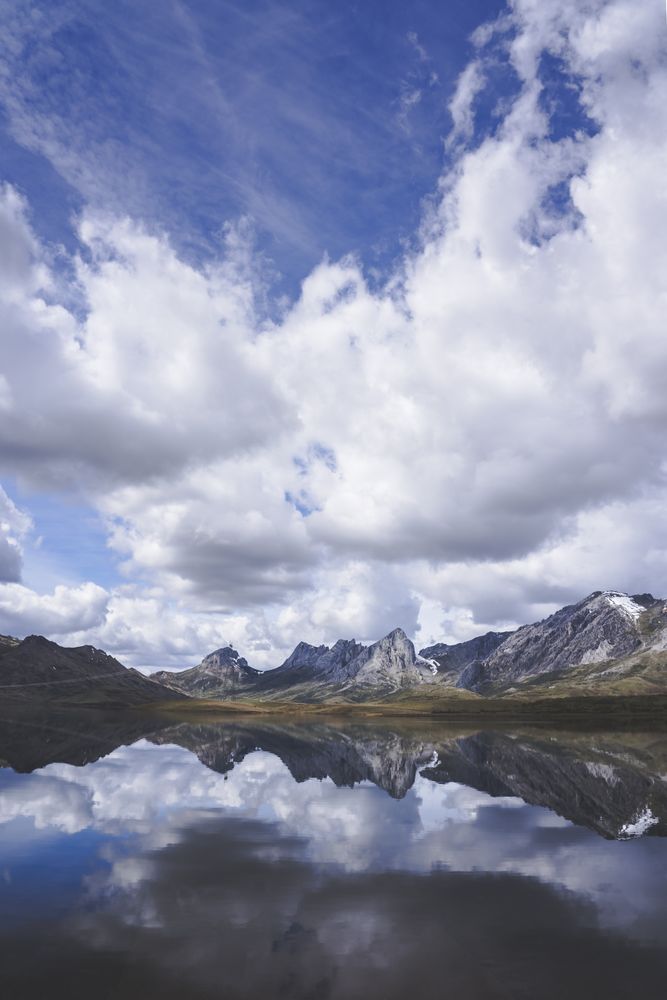 Cloudy sky over calm lake and mountains