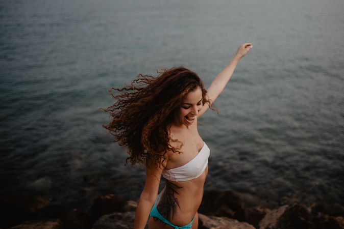 Smiling female dancing near sea