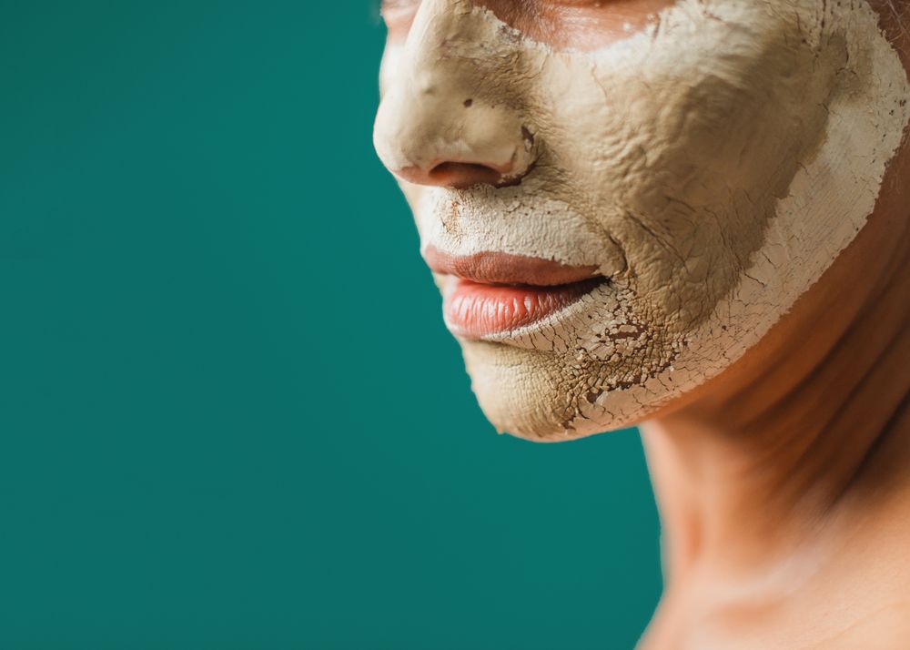 Crop female with dry clay mask