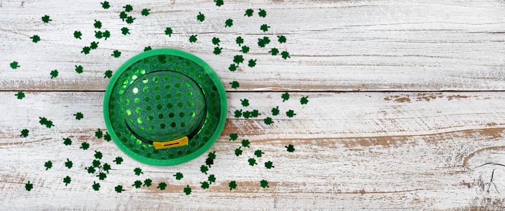 St Patrick’s day good luck hat and clovers on rustic wood in overhead view