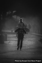 Back view of father holding daughter on his back walking on the road in grayscale 4NJGr4