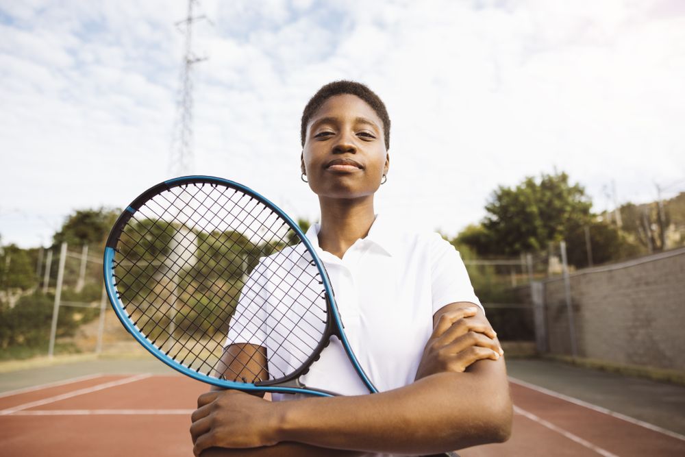Young women with a racket in a tennis court