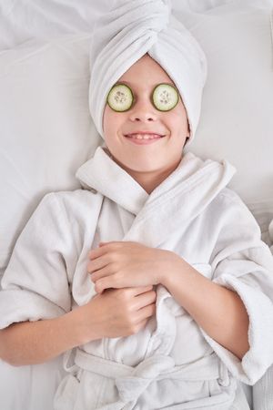 Happy boy resting during spa procedures at home