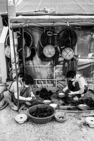 Grayscale people sitting on floor working in in Busan, South Korea