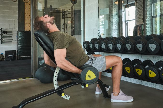 Strong man exercising with dumbbells in gym