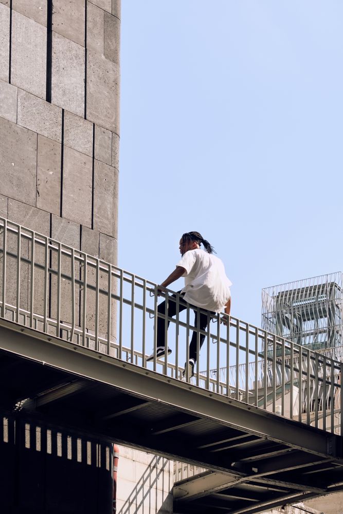 Black male sitting on bridge