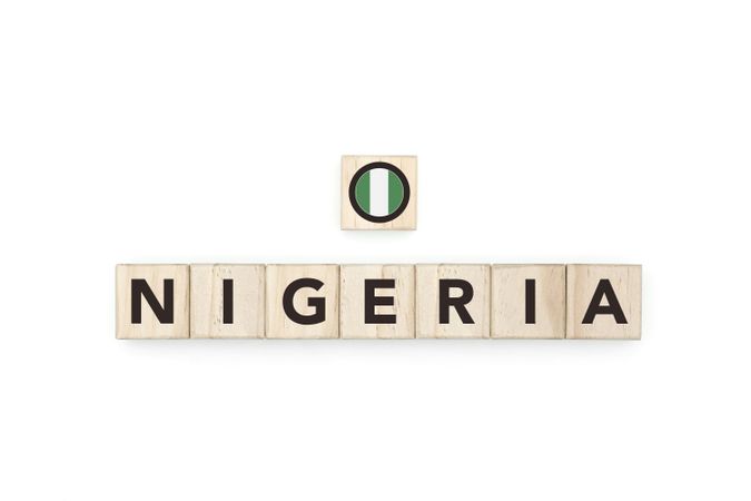 Wooden blocks bearing the name and flag of Nigeria. Nigerian and African Culture, national identity, travel, and geography in a copy space design.