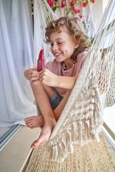 Cheerful smiling kid looking at red ice cream