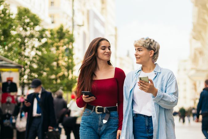 two women walking and using mobile