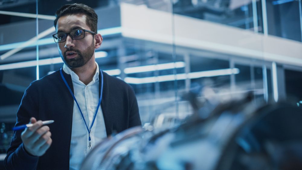 Smart Chief Engineer in Glasses Explaining Advanced Technology to a Team of College Students on an University Course.