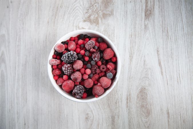 Ceramic bowl of frozen berries, horizontal