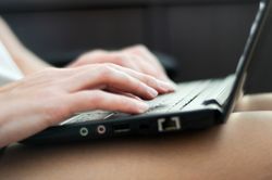 Hands typing on keyboard of laptop