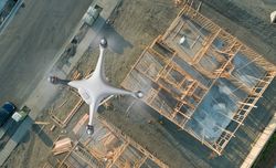 Unmanned Aircraft System Quadcopter Drone UAV In The Air Over Construction Site.
