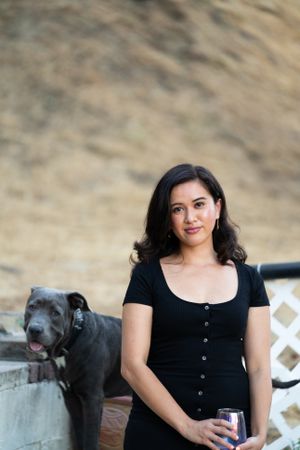 Portrait of woman smiling and looking at camera outside in front of hill