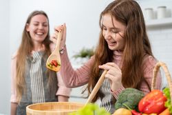 Girl with large salad bowl in bright kitchen