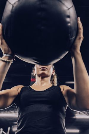 Muscular woman exercising with ball in gym