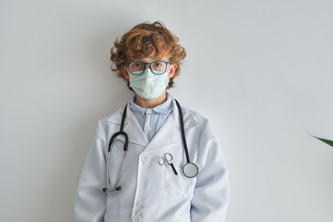 Boy doctor in sterile mask and uniform with stethoscope