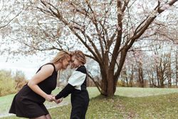 Mother and daughter standing under blooming tree