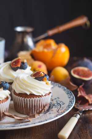 Homemade carrot cupcakes decorated with sweet frosting and fruit