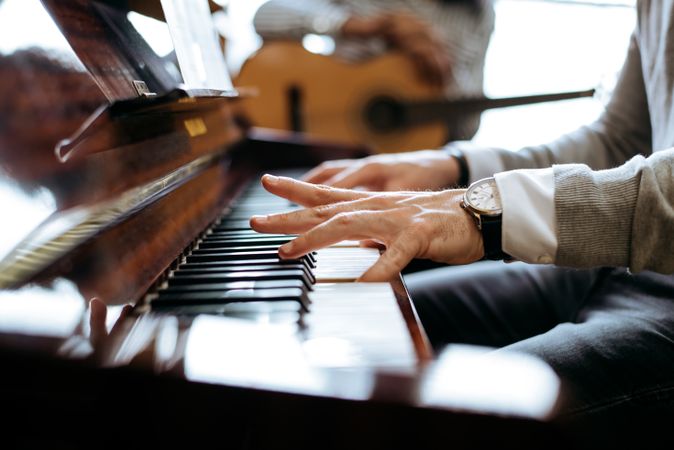 Crop male hands playing piano
