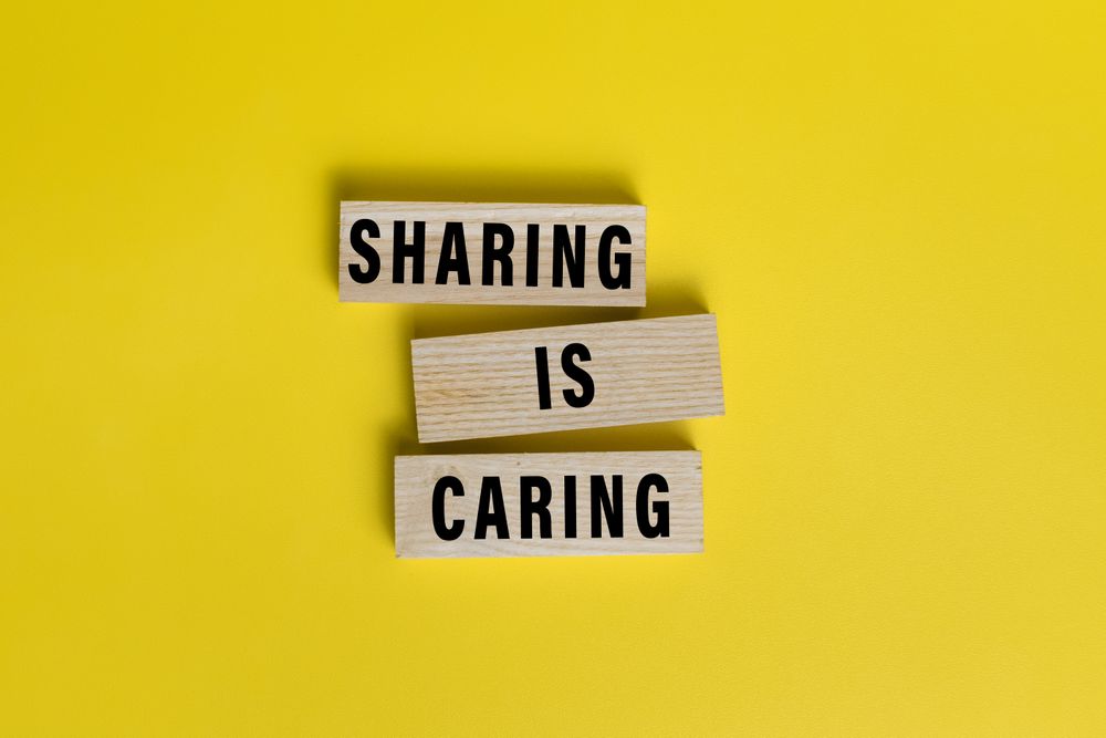 sharing is caring words text on wooden blocks isolated on yellow background