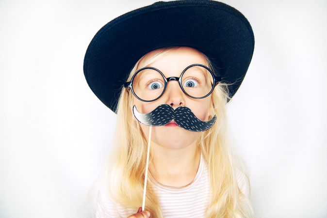 Blonde girl in hat, glasses and fake mustache