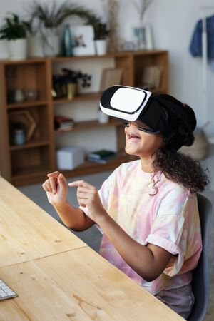 Young girl wearing Virtual Reality headset at home