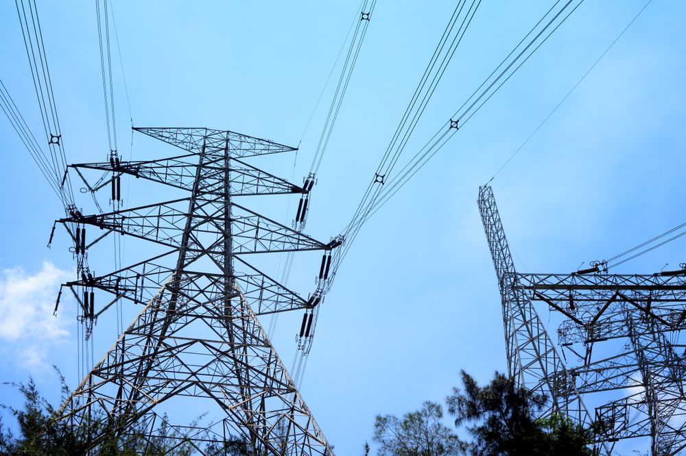 High Voltage Towers and Power Lines Against Clear Blue Sky Context